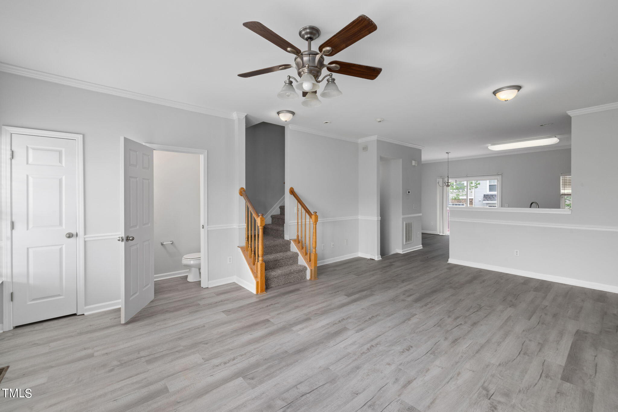 1237 Stone Manor Drive Raleigh, NC 27610 - Photo 12 of 29 a view of an empty room with wooden floor and a ceiling fan