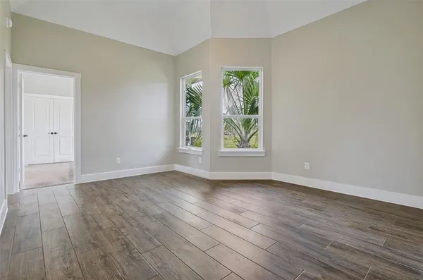 an empty room with wooden floor and window