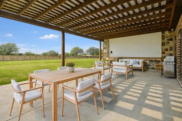 a view of a patio with chairs and table of the ocean