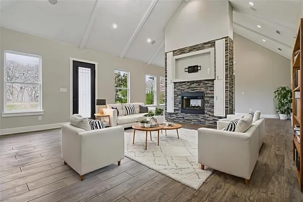 a living room with fireplace furniture and a large window
