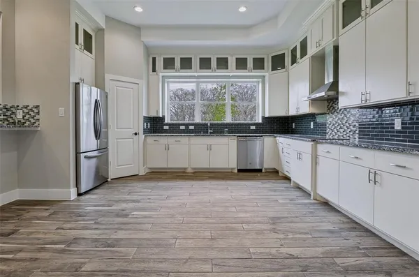 a kitchen with stainless steel appliances granite countertop a stove a sink and a refrigerator