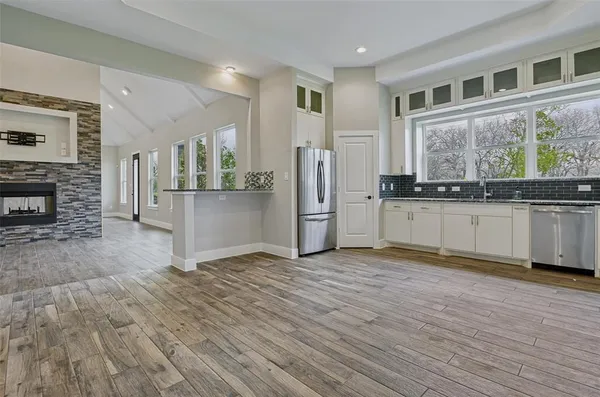 a view of a kitchen with a fridge wooden floor and a window