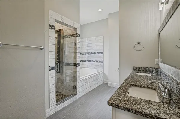 a bathroom with a granite countertop sink a mirror and shower