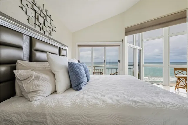 a large bed sitting in a bedroom next to a window