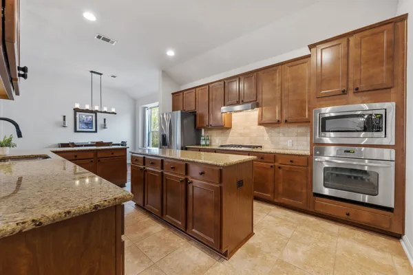 a kitchen with stainless steel appliances granite countertop a sink stove and refrigerator
