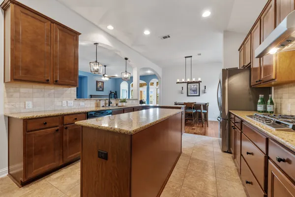 a kitchen with stainless steel appliances granite countertop a sink a stove and a refrigerator