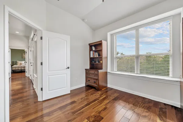 a view of a hallway with wooden floor and a living room