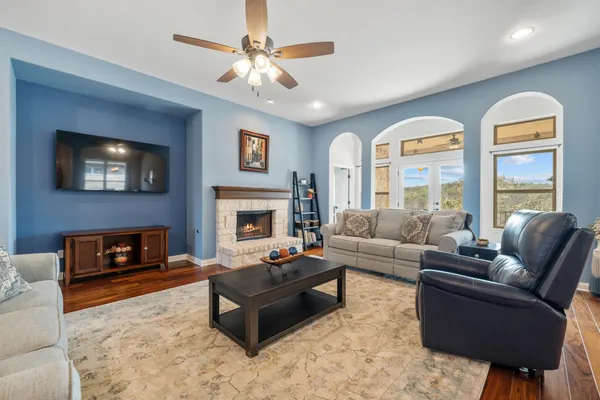 a living room with furniture fireplace and a large window