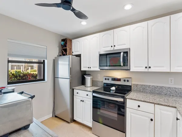 a kitchen with granite countertop a sink a stove and microwave