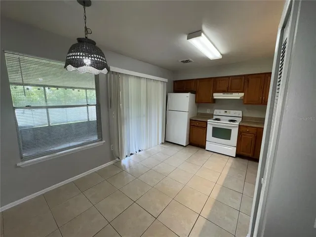 a kitchen with stainless steel appliances granite countertop a stove a refrigerator and a sink with wooden floor