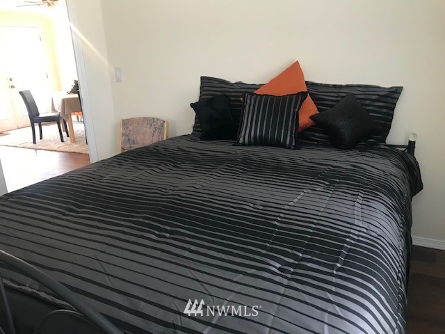 94 Main Road Tonasket, WA 98855 - Photo 11 of 25 a bedroom with a bed and wooden floor