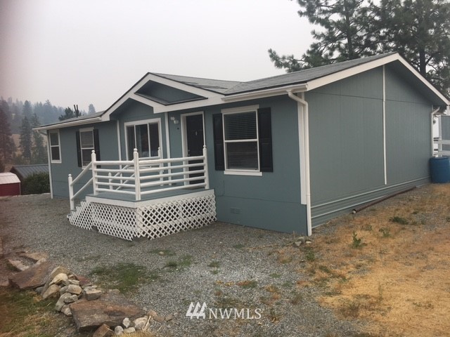 94 Main Road Tonasket, WA 98855 - Photo 3 of 25 a front view of a house with a yard