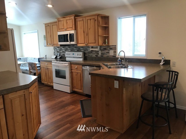 94 Main Road Tonasket, WA 98855 - Photo 8 of 25 a kitchen with granite countertop a sink stove and refrigerator