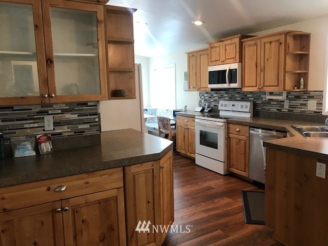 94 Main Road Tonasket, WA 98855 - Photo 9 of 25 a kitchen with stainless steel appliances a stove sink microwave and cabinets