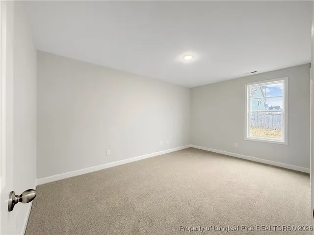 a view of a hallway with wooden floor and a bathroom