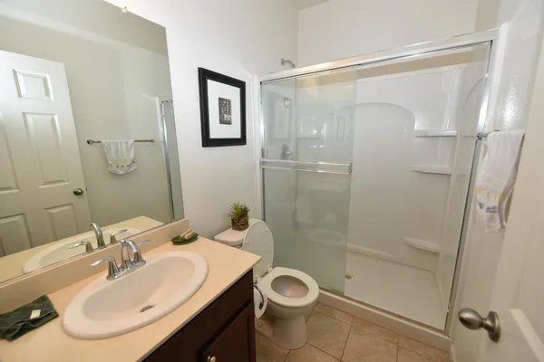 a bedroom with a bed a chandelier and dresser