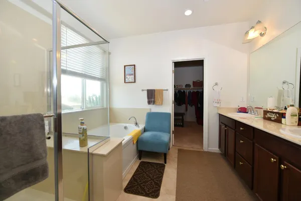 a bathroom with a tub sink and mirror