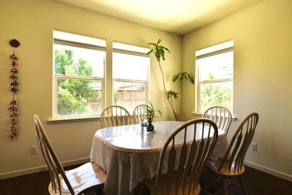 a kitchen with stainless steel appliances granite countertop a table chairs and a refrigerator