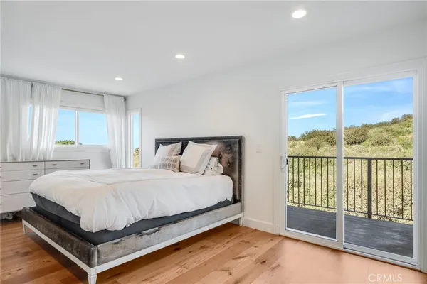 a spacious bedroom with a bed and a dresser