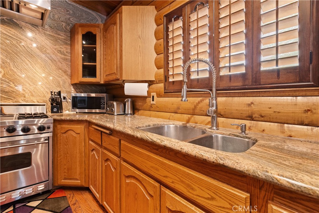 1870 Oak Springs Valley Road Wrightwood, CA 92397 - Photo 8 of 37 a kitchen with stainless steel appliances granite countertop a sink and a stove