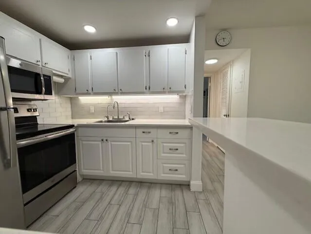 a kitchen with granite countertop a sink stove and cabinets