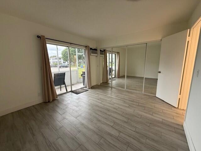 168 Northampton I West Palm Beach, FL 33417 - Photo 14 of 22 an empty room with wooden floor and windows