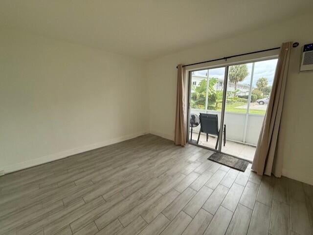 168 Northampton I West Palm Beach, FL 33417 - Photo 15 of 22 a view of an empty room with wooden floor and a window