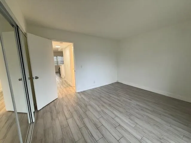 an empty room with wooden floor and entrance