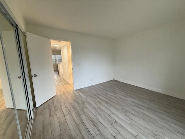 168 Northampton I West Palm Beach, FL 33417 - Photo 16 of 22 an empty room with wooden floor and entrance