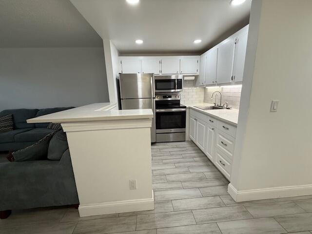 168 Northampton I West Palm Beach, FL 33417 - Photo 10 of 22 a kitchen with stainless steel appliances kitchen island granite countertop a refrigerator a stove a sink and white cabinets