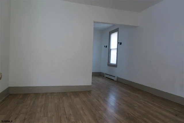 a view of a room with wooden floor and window