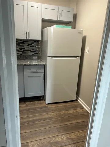 a white refrigerator freezer and a stove sitting inside of a kitchen