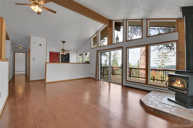 a view of an empty room with window and wooden floor