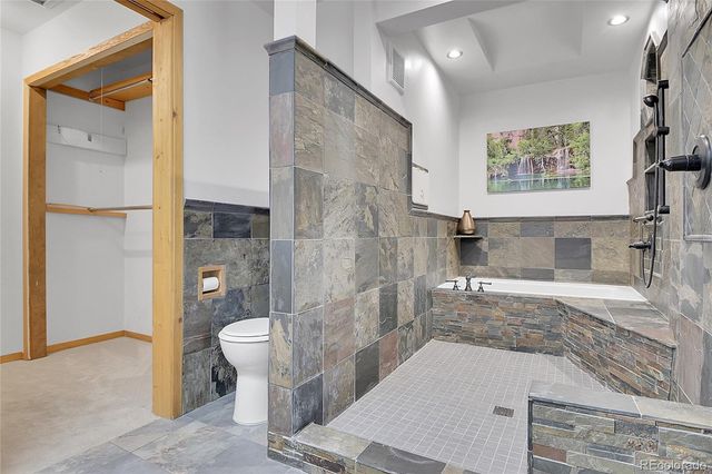 a bathroom with a granite countertop sink a toilet and shower