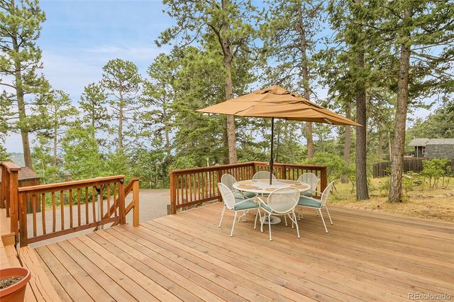 a balcony with wooden floor and outdoor seating