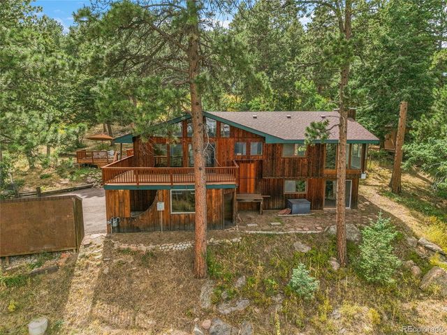 a view of a house with a large window and wooden fence