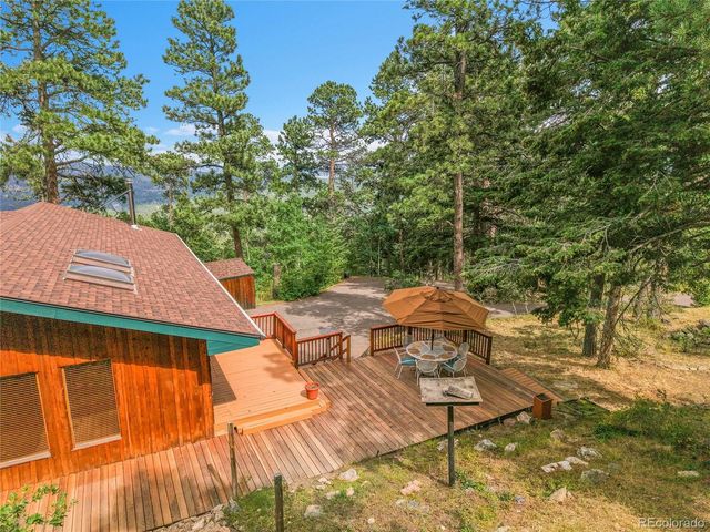 a view of a patio with table and chairs under an umbrella with wooden floor