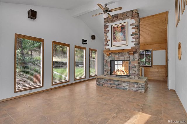 a view of an empty room with a fireplace and a window