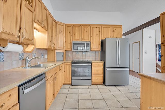 a kitchen with stainless steel appliances granite countertop a refrigerator and a sink