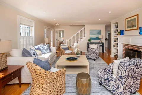 a living room with furniture a fireplace and wooden floor
