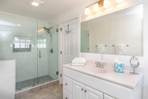 a bathroom with a shower sink vanity and mirror
