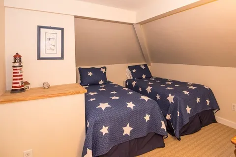 a bedroom with a bed and a dresser with mirror