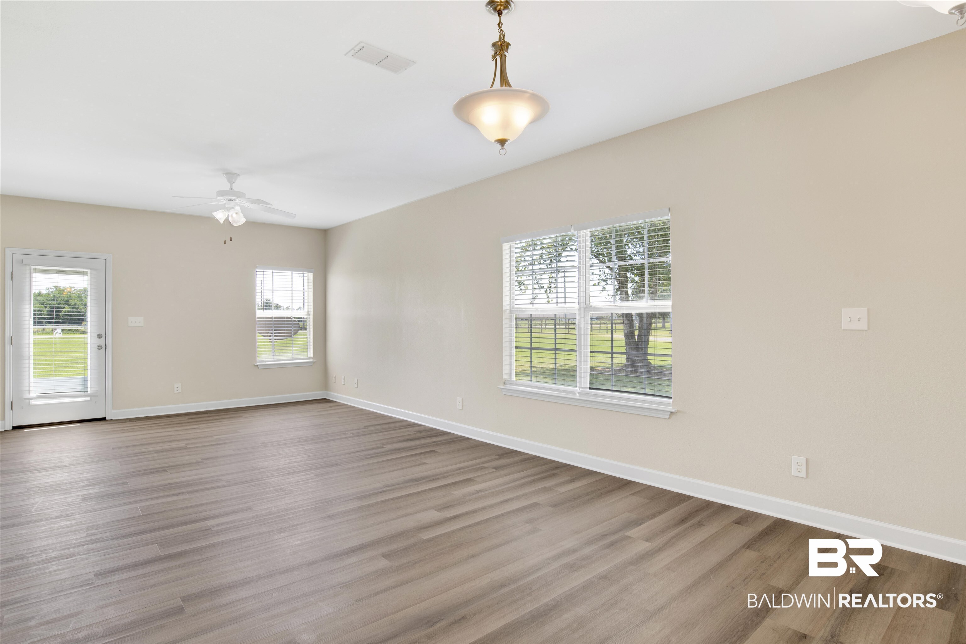 2002 Shelene Way Foley, AL 36535 - Photo 3 of 23 Unfurnished room featuring wood finished floors, healthy amount of natural light, and ceiling fan