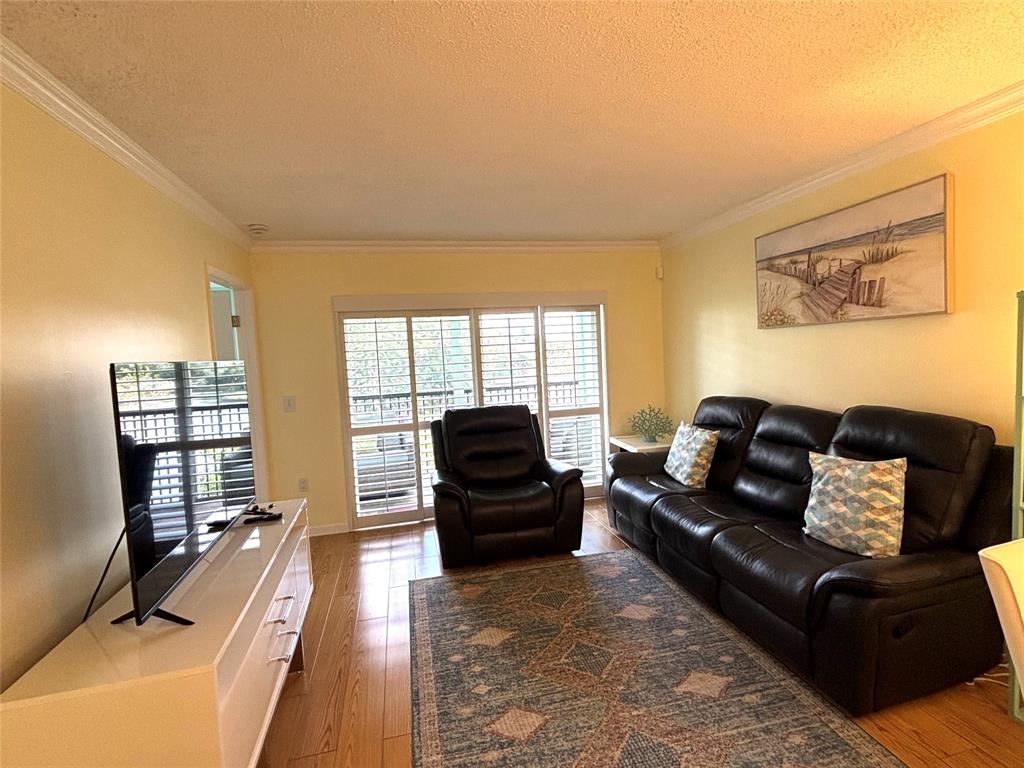 2236 North Cypress Bend Drive, Unit 304 Pompano Beach, FL 33069 - Photo 12 of 17 a living room with furniture and a flat screen tv