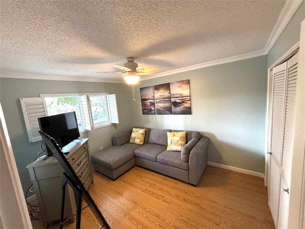 2236 North Cypress Bend Drive, Unit 304 Pompano Beach, FL 33069 - Photo 15 of 17 a living room with furniture and a flat screen tv