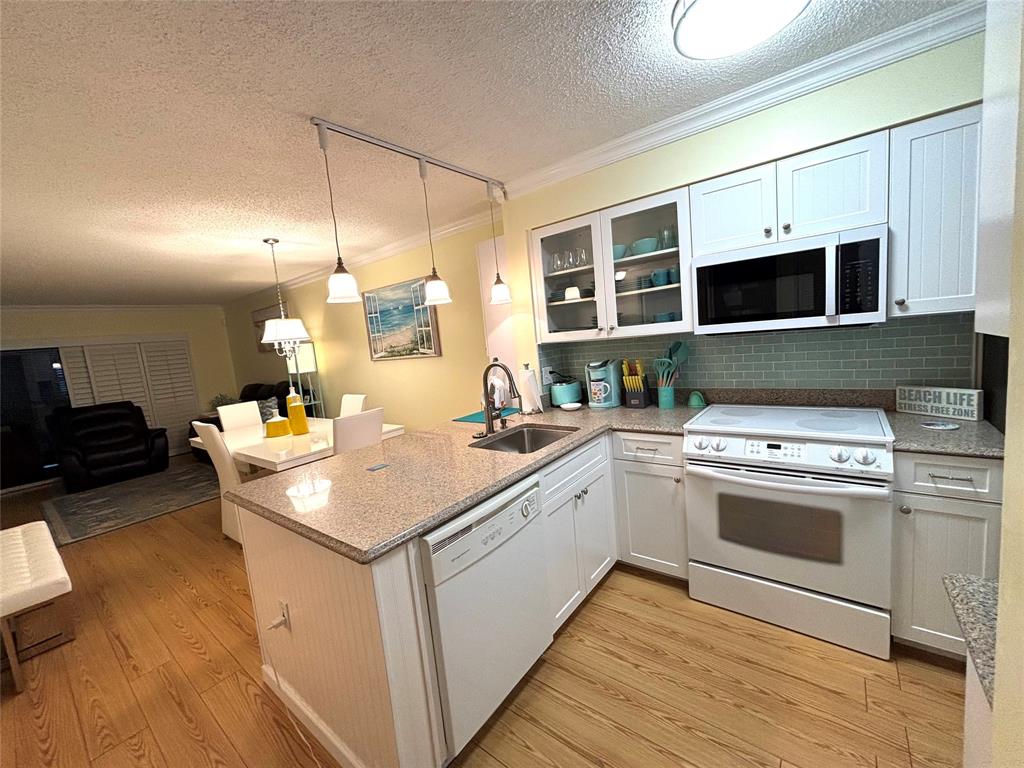 2236 North Cypress Bend Drive, Unit 304 Pompano Beach, FL 33069 - Photo 7 of 17 a kitchen with a stove and a sink