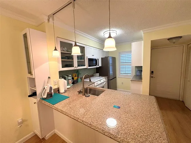 a kitchen with stainless steel appliances granite countertop a sink refrigerator and microwave