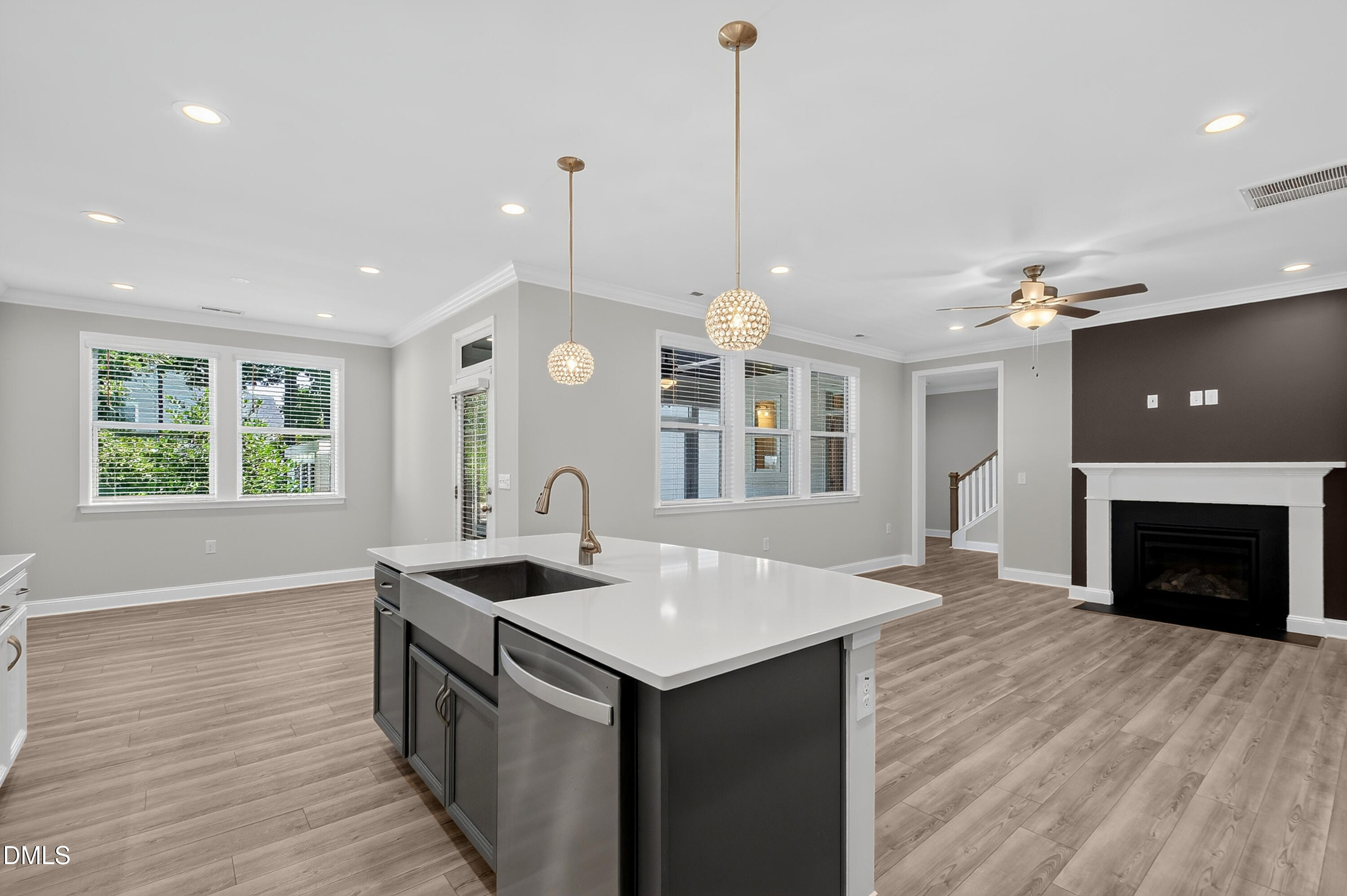 1300 Commons Ford Place Apex, NC 27539 - Photo 13 of 70 a kitchen with a sink chandelier and a fireplace