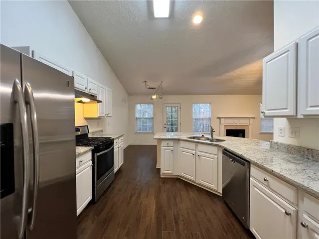 a kitchen with granite countertop stainless steel appliances and wooden cabinets