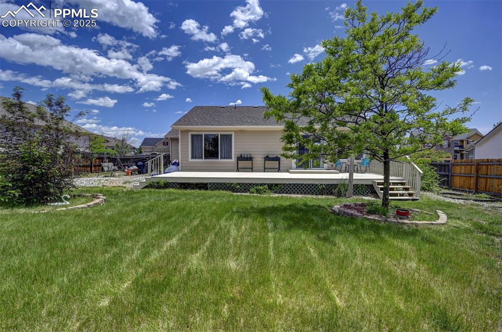 12593 Pine Valley Circle Peyton, CO 80831 - Photo 15 of 17 Back of house featuring a fenced backyard and a wooden deck